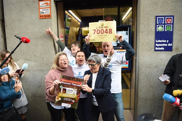 Empleados de la administración situada en la calle del Barquillo 10, celebran que han vendido el número 70048 correspondiente al Segundo Premio del Sorteo Extraordinario de la Lotería de Navidad 2025, a 22 de diciembre de 2025, en Madrid (España). 