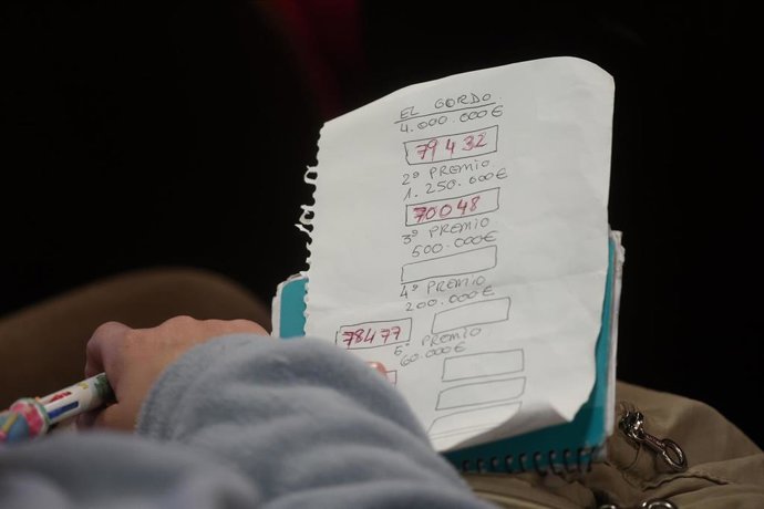 Un hombre apunta los números que van premiando durante la celebración del Sorteo Extraordinario de la Lotería de Navidad 2025. 