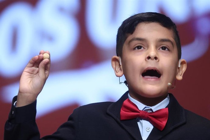 Un niño del Colegio de San Ildefonso canta el tercer premio de la Lotería de Navidad