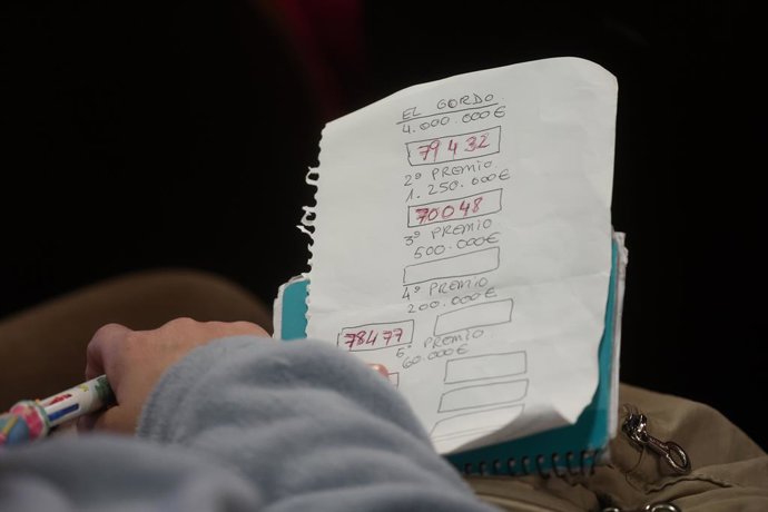 Un home apunta els nombres que van premiant durant la celebració del Sorteig Extraordinari de la Loteria de Nadal 2025. 