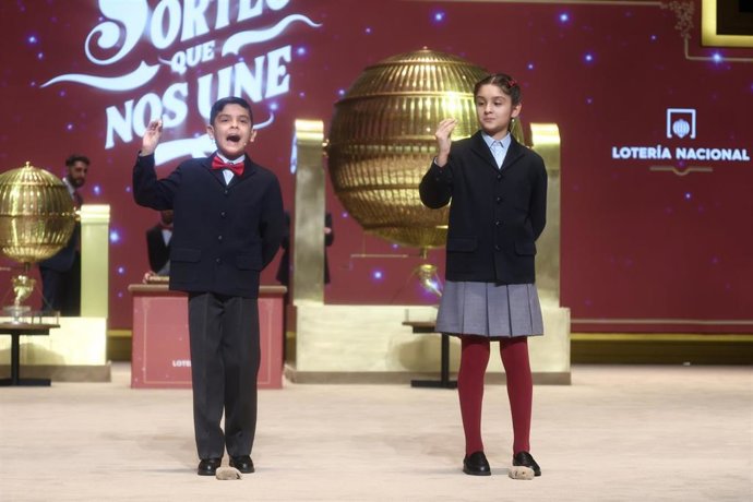 Dos niños del Colegio de San Ildefonso cantan el tercer premio de la Lotería de Navidad, durante la celebración del Sorteo Extraordinario de la Lotería de Navidad 2025, en el Teatro Real, a 22 de diciembre de 2025, en Madrid (España).