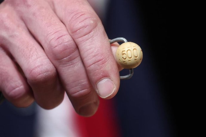 Un hombre mete las bolas con los premios en el bombo de la lotería durante la celebración del Sorteo Extraordinario de la Lotería de Navidad 2025, en el Teatro Real, a 22 de diciembre de 2025, en Madrid (España).