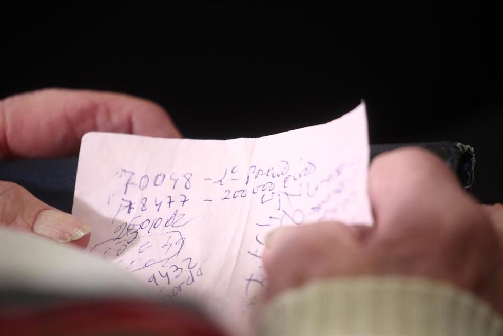 Una mujer revisa sus números para ver si han sido premiados durante la celebración del Sorteo Extraordinario de la Lotería de Navidad 2025, en el Teatro Real, a 22 de diciembre de 2025, en Madrid (España).
