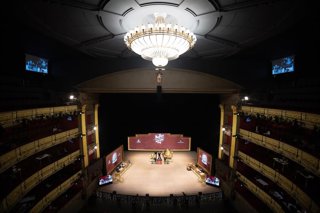 Varias personas ven como los niños del Colegio de San Idefonso cantan los números premiados durante la celebración del Sorteo Extraordinario de la Lotería de Navidad 2025.