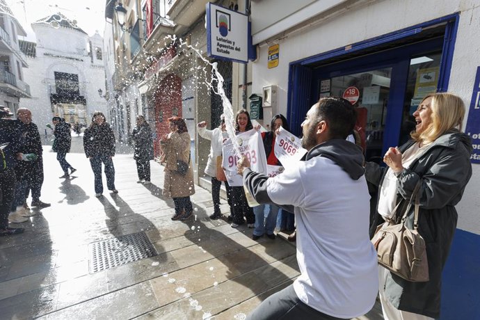A Administração da Loteria da rua Isabel la Católica, em Santa Fé (Granada), distribui o terceiro prêmio do sorteio de Natal entre seus vizinhos, que abriram uma garrafa de champanhe.