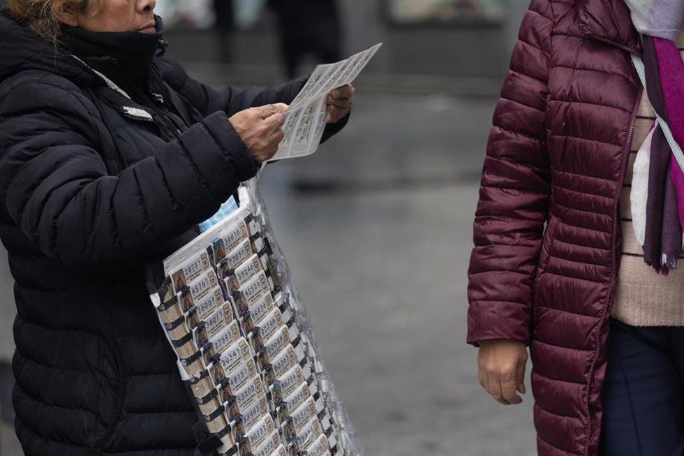 Archivo - Una persona vende Lotería de Navidad, a 9 de diciembre de 2022, en Madrid (España). El Sorteo Extraordinario de Navidad 2022 se celebrará el próximo 22 de diciembre, y repartirá 2.520 millones de euros. Este año se ha incrementado el número de