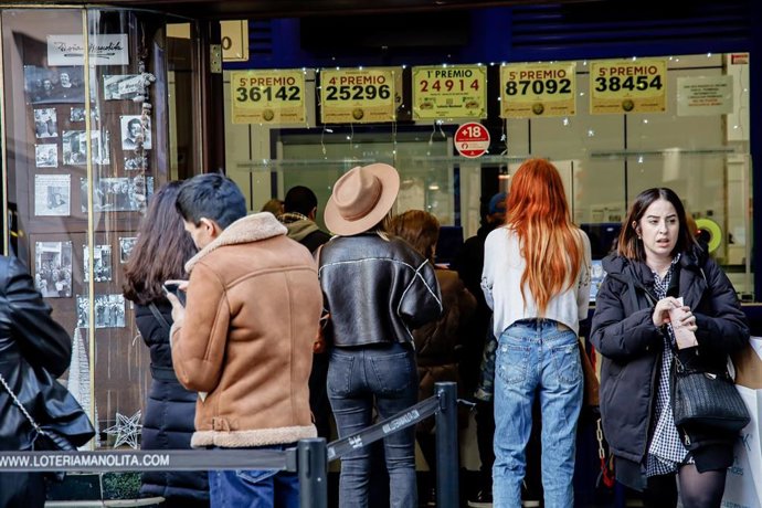 Archivo - Varias personas hacen cola para comprar lotería para el Sorteo Extraordinario del Niño.