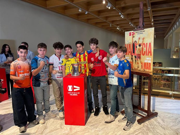 Ocho niños representando a cada uno de los ocho participantes posan junto al trofeo de la Copa del Rey de voleibol tras el sorteo del cuadro final en el Museo de Bellas Artes de Valencia