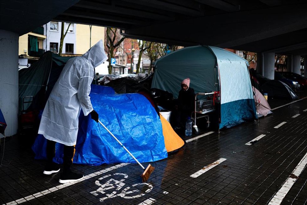 Personas desalojadas del antiguo Instituto B9 de Badalona acampan debajo de la salida 210 de la C-31, en el barrio de Sant Roc, a 20 de diciembre de 2025, en Badalona, Barcelona, Catalunya (España). Las fuertes lluvias que se han abierto paso en las últ