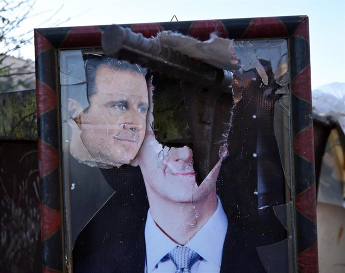 Archivo - Cartel vandalizado con la imagen del expresidente sirio Bashar al Asad
