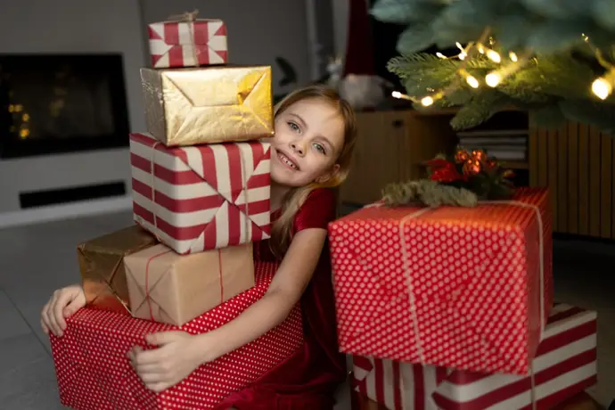 Niña con muchos regalos de Navidad.