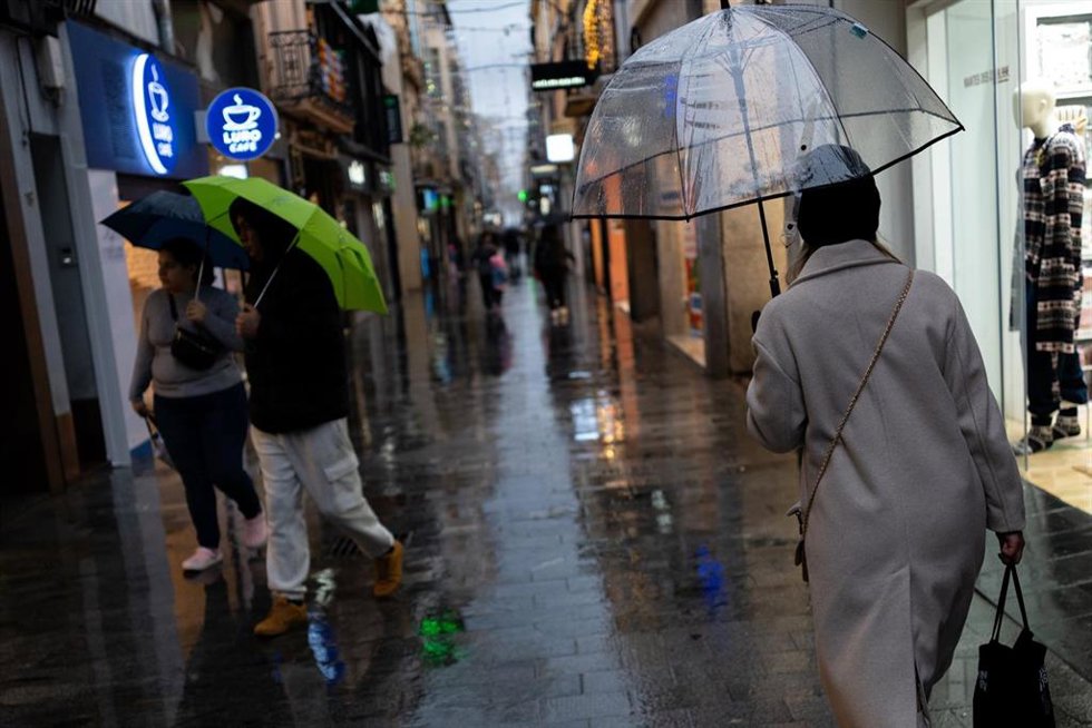 Varias personas caminan con paraguas, a 20 de diciembre de 2025, en Badalona, Barcelona, Catalunya (España). 