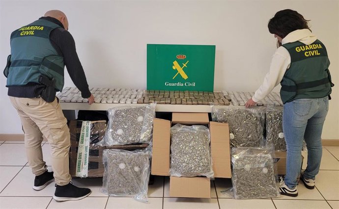 Dos agentes de la Guardia Civil, con la droga incautada.