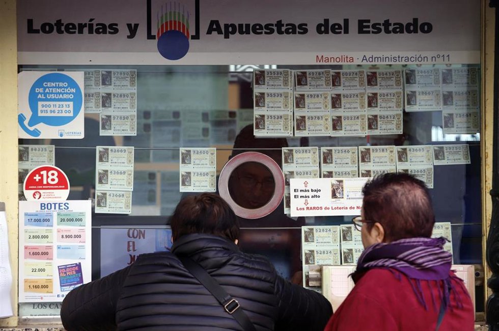 Archivo - Varias personas en una administración de Lotería en Málaga en una imagen de archivo