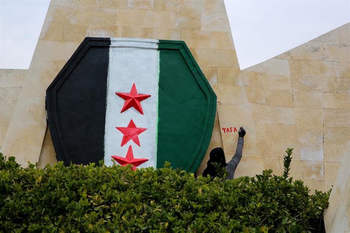 Archivo - Nueva bandera siria pintada sobre la fachada de un edificio en Hama, en el oeste de Siria