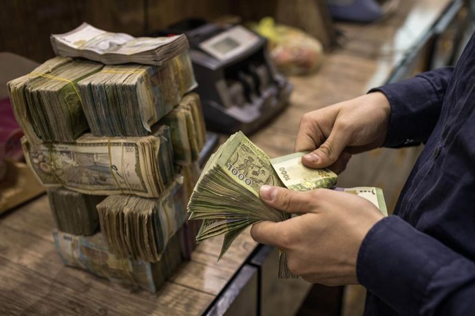Arquivo - 9 de outubro de 2023, Raqqa, Síria: Um homem conta maços de libras sírias que totalizam o equivalente a dez dólares americanos. Constantemente desvalorizada por anos de guerra e inflação, a moeda agora não vale quase nada. Atualmente, 1 dólar am