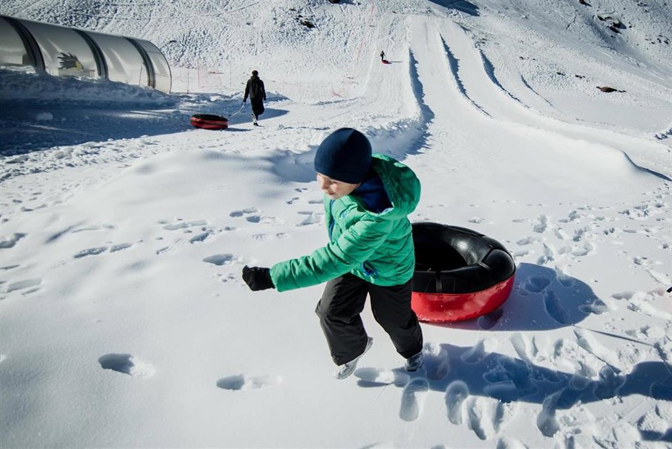 Archivo - Un niño se dispone a lanzarse con un flotador en la zona de Borreguiles de la Estación de Sierra Nevada. Archivo.