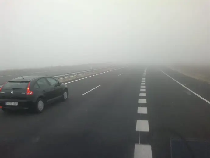 La niebla dificulta la visibilidad en una carretera. Imagen de archivo