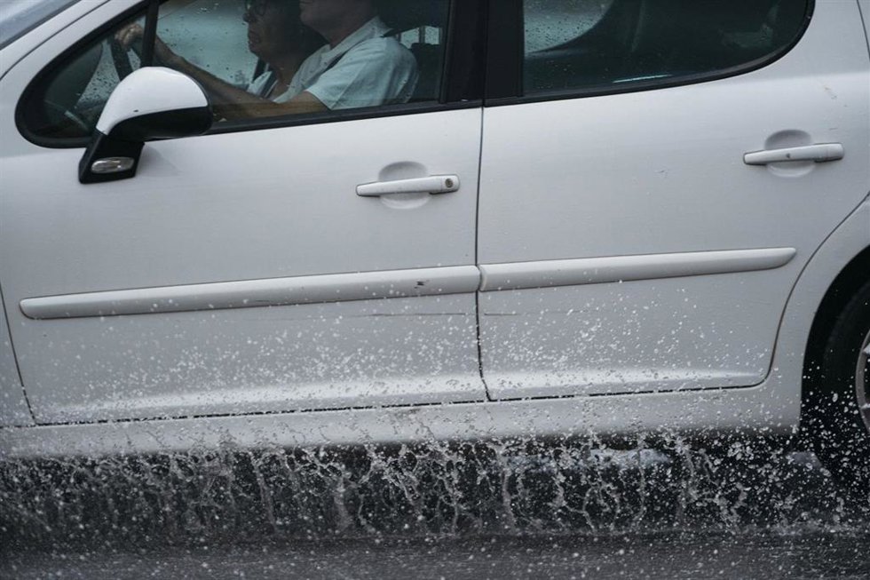 Archivo - Un coche circula bajo la lluvia.