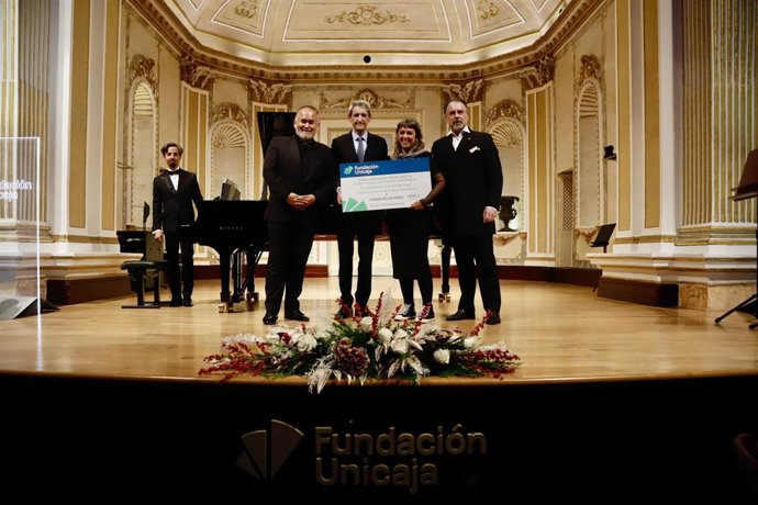 El presidente de la Fundación Unicaja, José M. Domínguez, hizo entrega del cheque con la recaudación a la coordinadora de La Ciudad de los Niños, Elena Pernías, al inicio del recital de Camarena y Álvarez