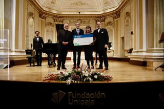 El presidente de la Fundación Unicaja, José M. Domínguez, hizo entrega del cheque con la recaudación a la coordinadora de La Ciudad de los Niños, Elena Pernías, al inicio del recital de Camarena y Álvarez