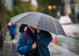 Archivo - Sevillanos protegiéndose de la lluvia y el viento, protagonistas de la jornada de hoy con avisos naranja y amarillo en gran parte de Andalucía. A 13 de noviembre de 2025, en Sevilla (Andalucía, España). Andalucía vuelve a estar bajo la influenci