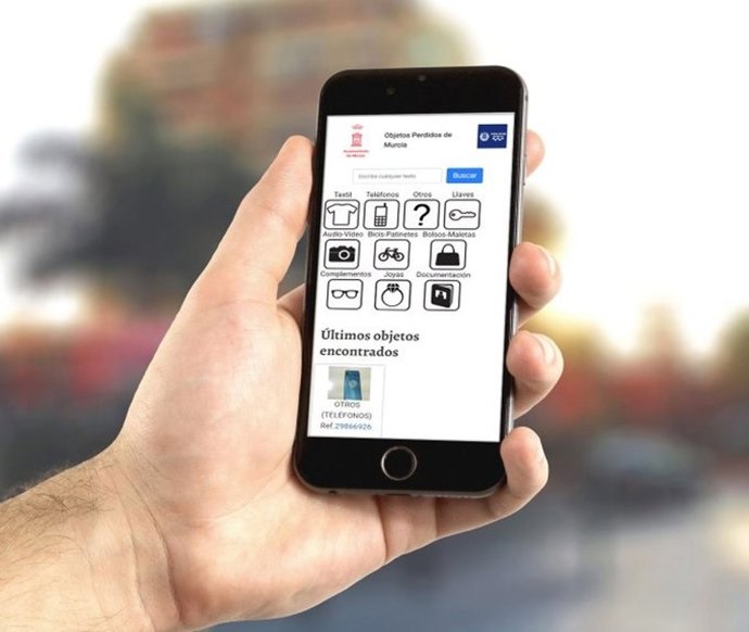 Un hombre porta un teléfono móvil donde se puede ver la página de la Oficina de Objetos Perdidos de la Policía Local de Murcia