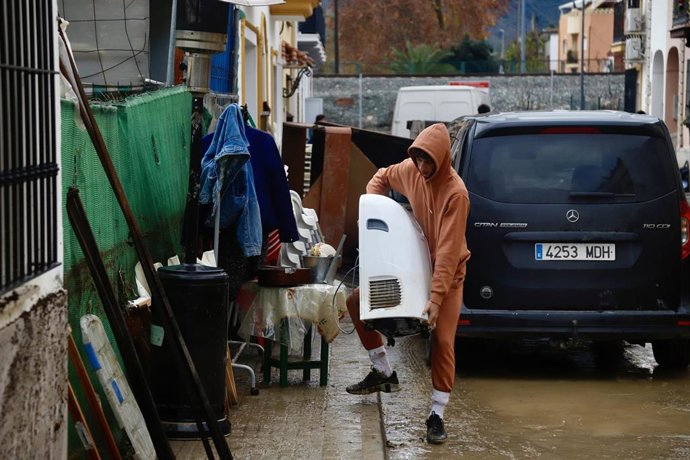 Imagen de archivo de vecinos de la barriada de Los Cardiales en Cártama (Málaga) limpiando el barro en sus casas tras las intensas lluvias de la madrugada, a 28 de diciembre de 2025. 