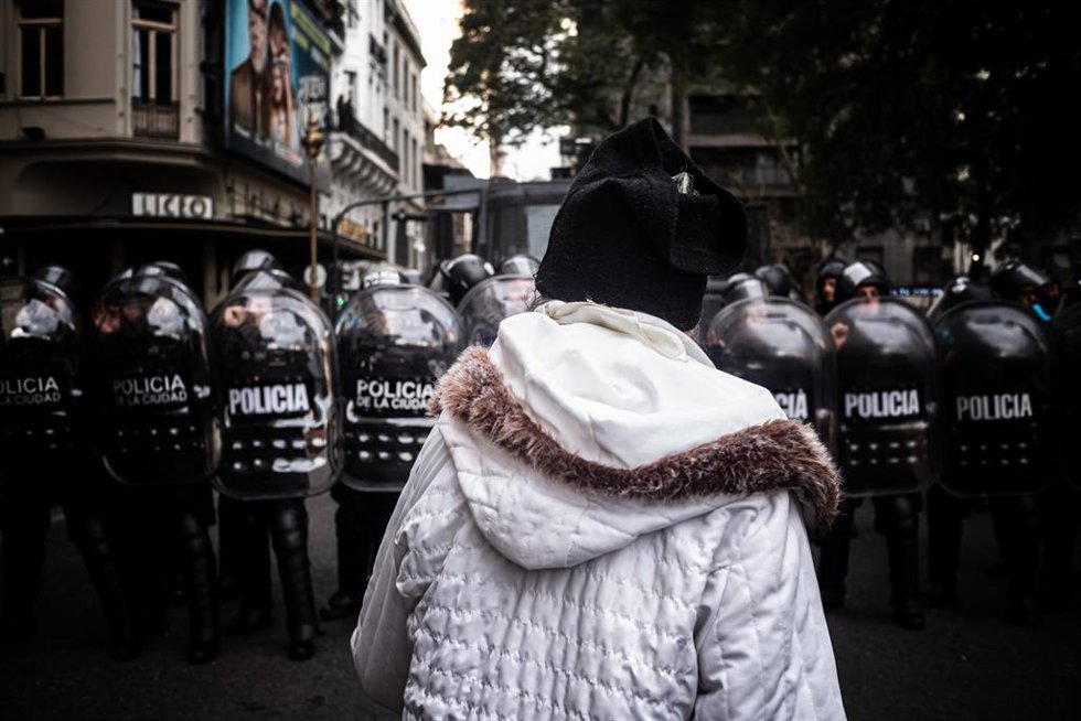 Archivo - Una persona situada frente a una fila de policías antidisturbios en una manifestación en Buenos Aires, Argentina
