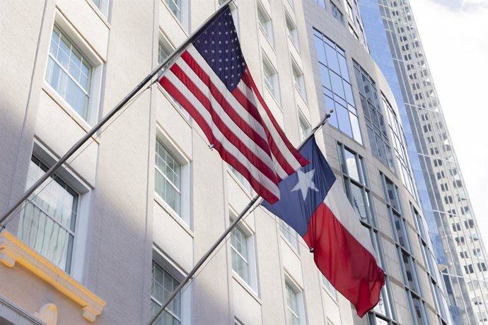 Archivo - 25 de julho de 2022, Houston, França, EUA: Houston, EUA 25 de julho de 2022 - O distrito comercial no centro de Houston - Uma bandeira do Texas e dos EUA hasteada na entrada de um prédio de escritórios.HOUSTON, DOWNTOWN, EUA, ETATS UNIS, TEXAS, 