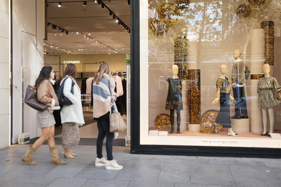 Archivo - Varias mujer miran la entrada de una tienda de moda