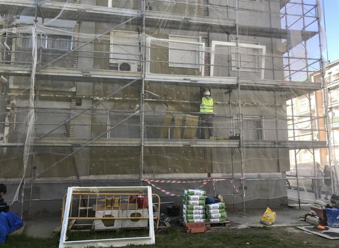 Archivo - Operarios trabajan subidos a un andamio 