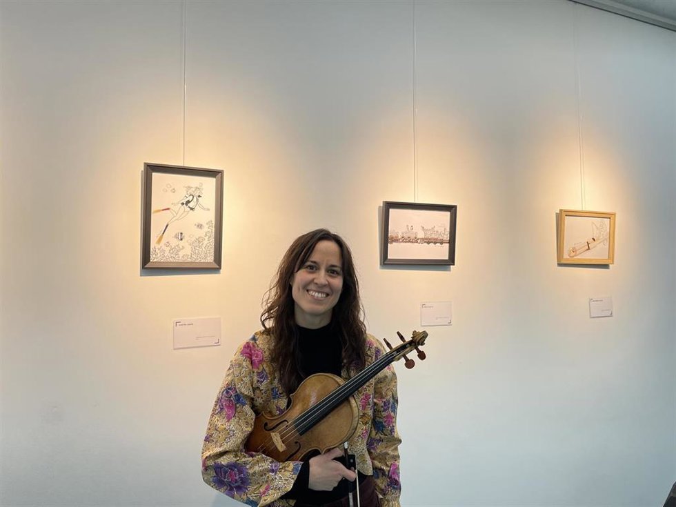 La ilustradora y violinista, Ana Simón, junto a sus 39 cuadros de la obra 'Minimúsicos'.