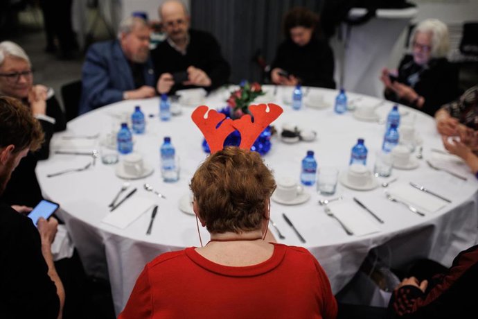 Archivo - Varias personas durante una cena navideña 