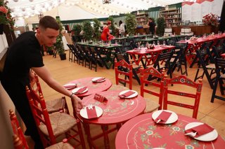 Archivo - Un camarero prepara las mesas del interior de una caseta de la Feria de abril de Sevilla. A 07 de mayo de 2025, en Sevilla (Andalucía, España). 