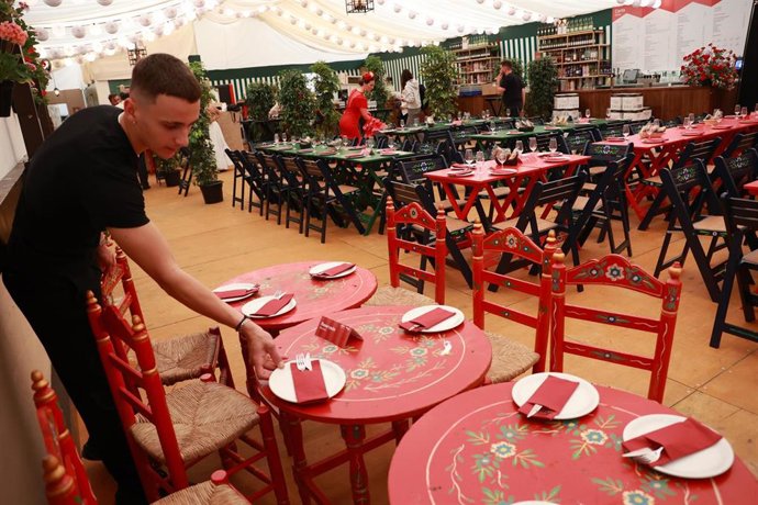 Archivo - Un camarero prepara las mesas del interior de una caseta de la Feria de abril de Sevilla. A 07 de mayo de 2025, en Sevilla (Andalucía, España). 