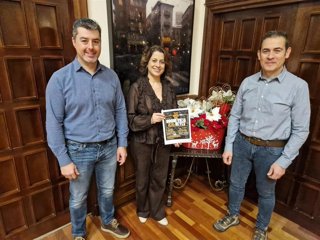 La alcaldesa de Teruel, Emma Buj, presenta el cartel festivo de la carpa de Nochevieja y Reyes junto con el concejal de Fiestas, Eduardo Suárez, y el representante del Club Deportivo Teruel, Valentín Calvo.