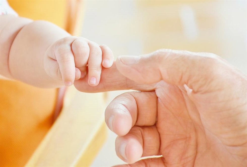 Archivo - Imagen de una mano de un bebé y su madre.