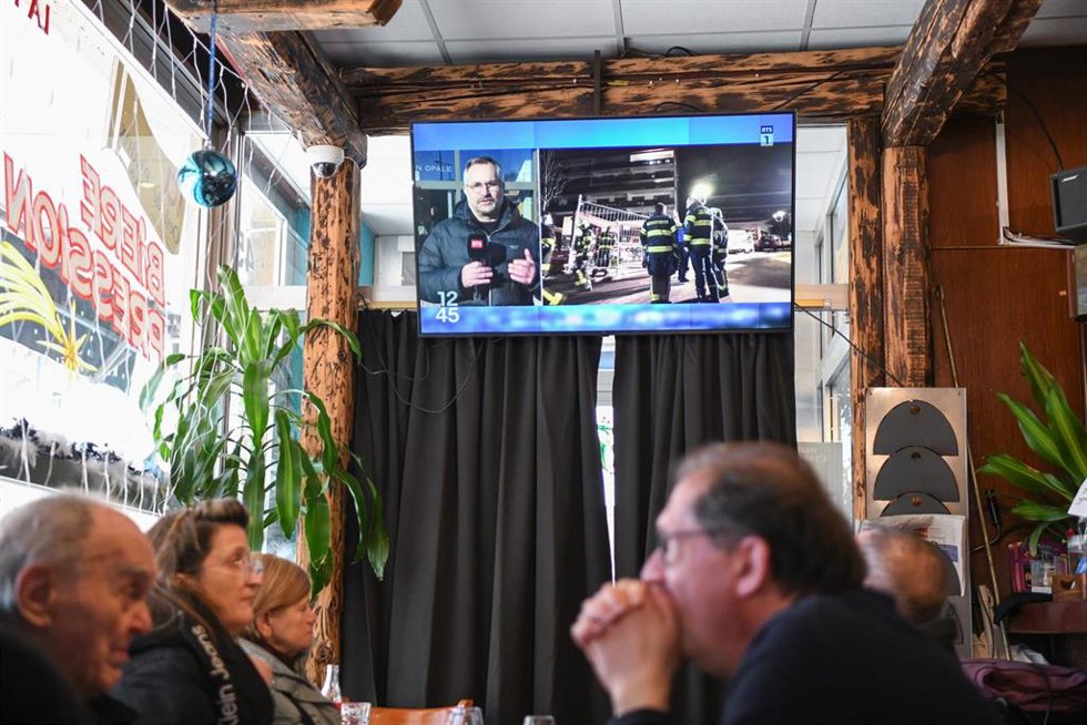 Televisor en Ginebra retransmite la noticia del accidente durante una fiesta en una estación de esquí de Suiza que se ha cobrado la vida de alrededor de 40 personas