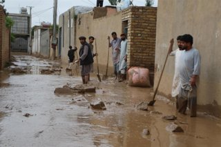 Archivo - Residentes de Faryab, una de las provincias afectadas, limpian de lodo la calle tras inundaciones repentinas