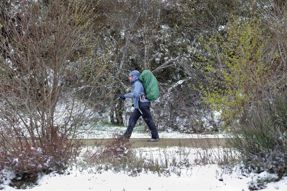 Archivo - Una peregrina realiza el Camino de Santiago entre la nieve, a 20 de abril de 2022, en O Cebreiro, Lugo, Galicia (España). Después de una Semana Santa con altas temperaturas y en mitad de la primavera, Galicia vuelve al invierno con temperatura