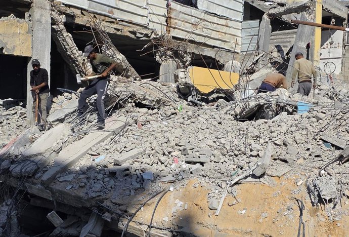 December 25, 2025, Khan Yunis, Gaza Strip, Palestinian Territory: Palestinian Shop owners in Khan Yunis, in southern Gaza Strip, remove debris by hand and rebuild their damaged stores using stones and red clay, as they struggle to resume their livelihoods