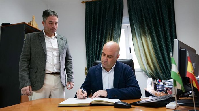 El presidente de la Diputación de Almería, José Antonio García Alcaina, firma en el libro de honor del Ayuntamiento de Uleila del Campo, junto a su alcalde, Juan José Fuentes.