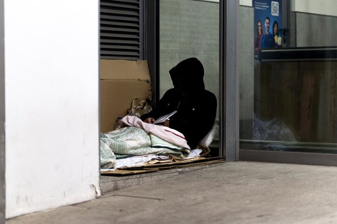 Una persona sense llar dorm en el carrer en imatge d'arxiu