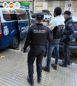 El arrestado, de espaldas, junto a dos agentes de la Policía Nacional.
