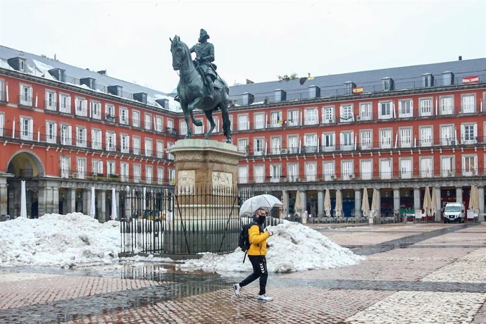 Archivo - Imagen de archivo de un hombre caminando por la plaza Mayor de Madrid tras el paso de la borrasca 'Filomena'.