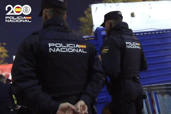 Dos agentes de la Policía Nacional, de espaldas.