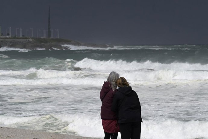 Archivo - Dos mujeres observan las olas durante el frente meteorológico, a 23 de febrero de 2024, en A Coruña, Galicia (España)