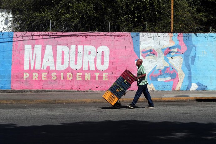 Archivo - August 20, 2025, Valencia, Carabobo, Venezuela: August 20, 2025. A man walks past graffiti depicting Venezuelan President Nicolas Maduro. The United States is offering a $50 million reward for information leading to his capture. In the city of V
