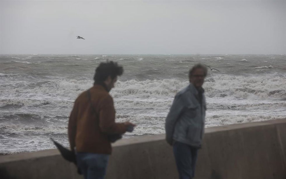 Archivo - Dos personas caminan en la Playa de la Malvarrosa